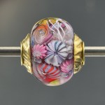 artisan lampwork focal bead with handmade murrini and brass end caps